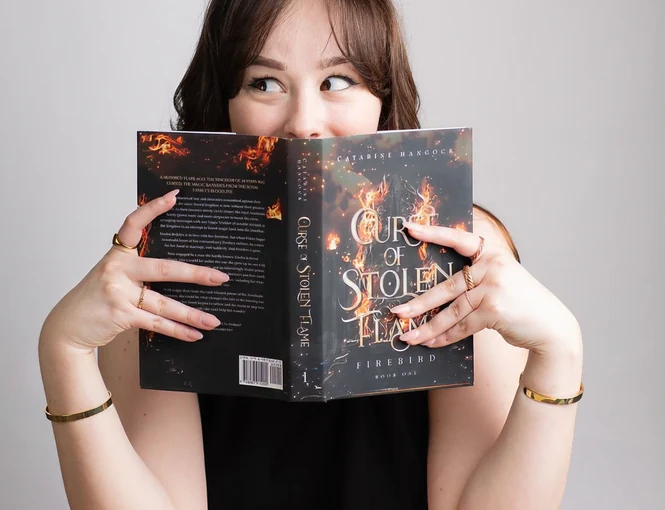 An author holding an open book